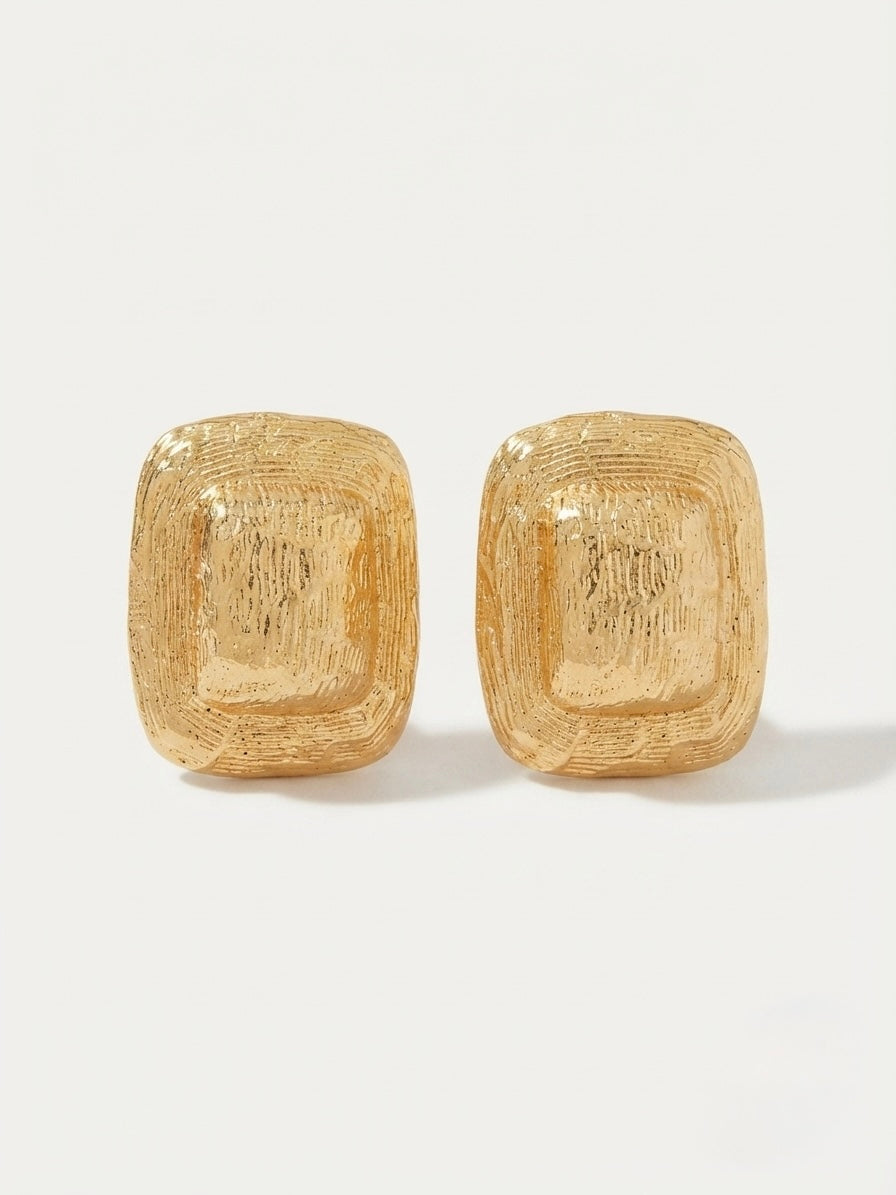 Terra Earrings — chunky rounded rectangular gold earrings with etched linear texture, shown as a pair on white background