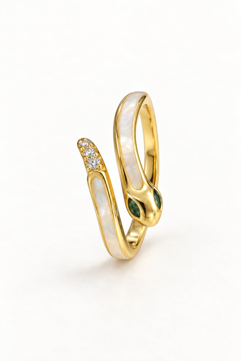 Gold-tone snake ring with pale contrast panels, green eyes and clear accents at the tail