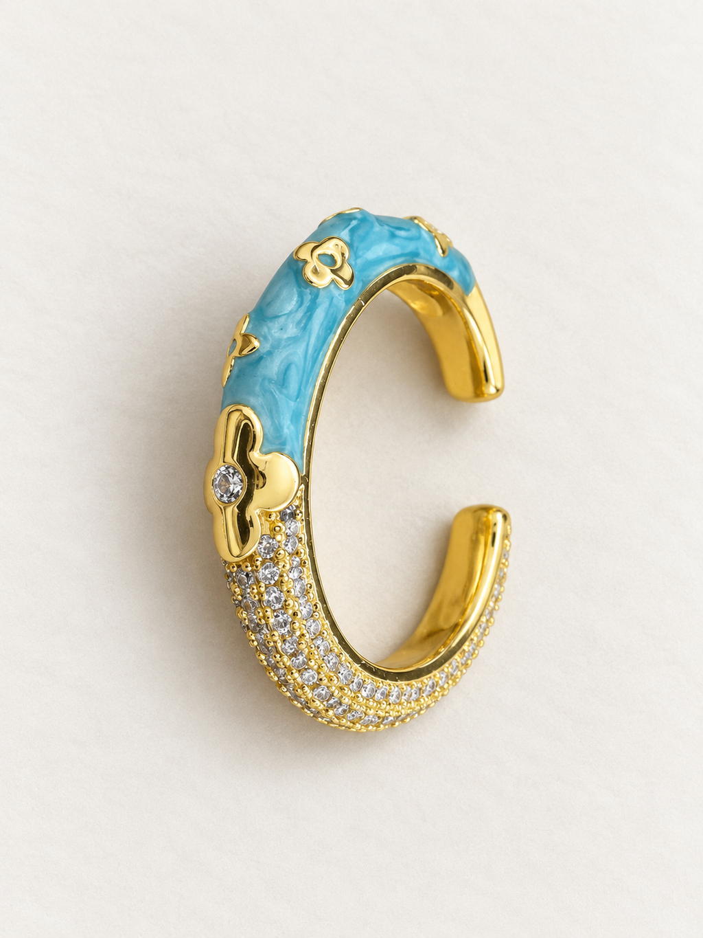 Open gold-tone ring with marbled blue floral side and sparkling clear-accent side