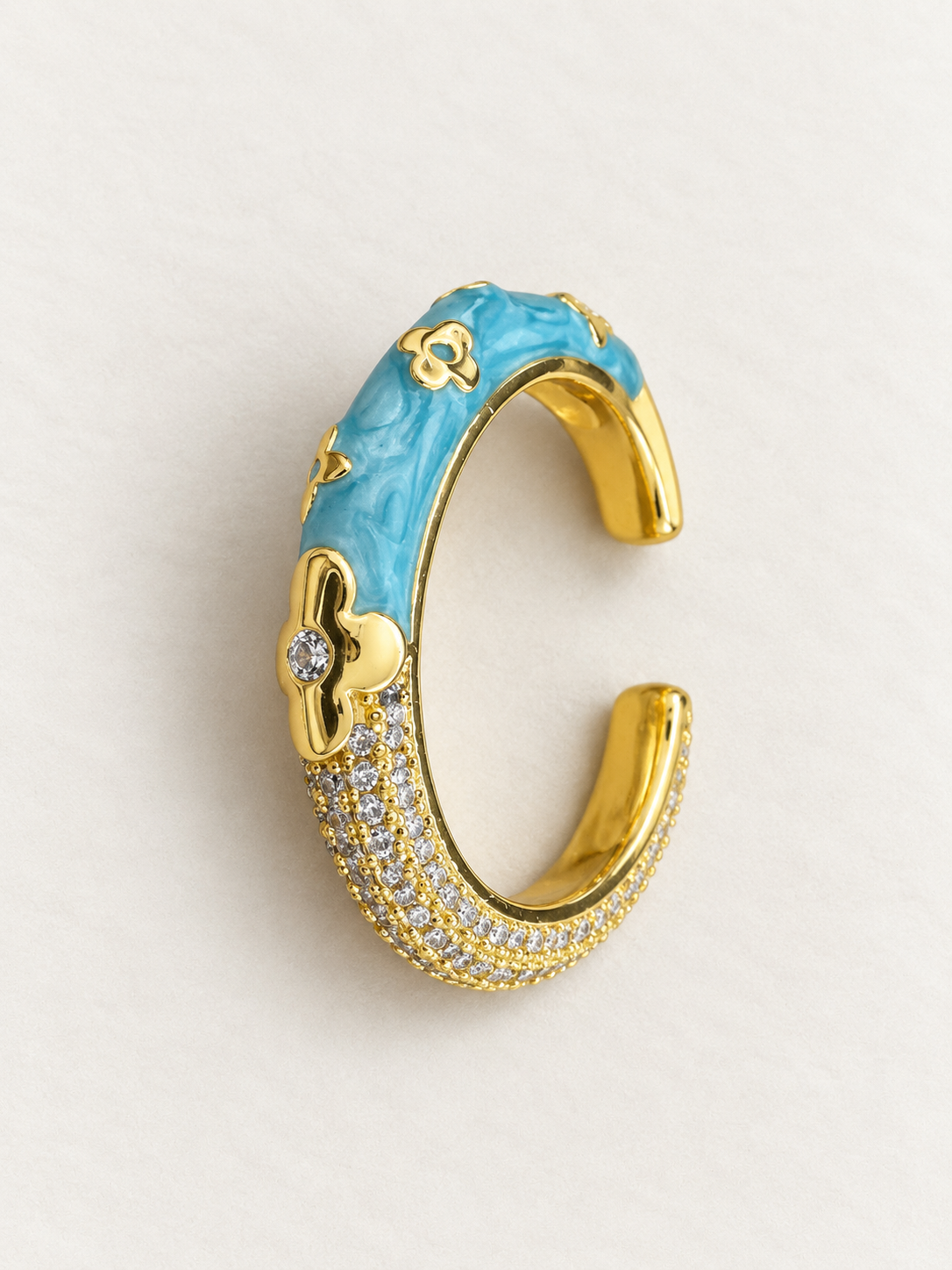 Open gold-tone ring with marbled blue floral side and sparkling clear-accent side