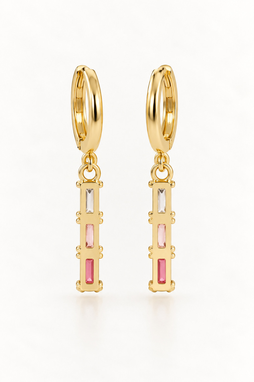 A pair of gold huggie hoop earrings with vertical rectangular bar charms featuring pink, white, and gold baguette-cut stones, shown on a clean white background.